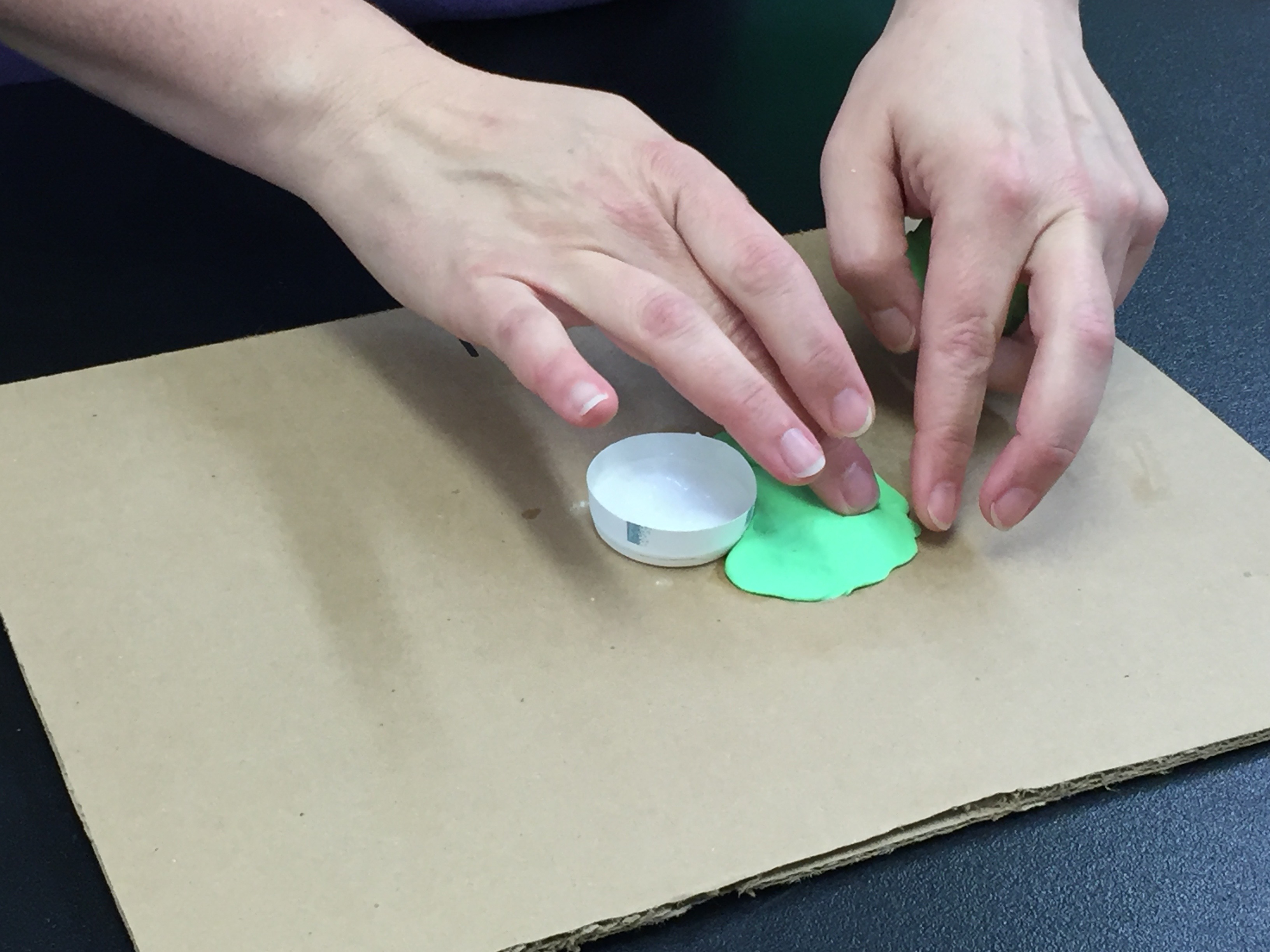 placing the play dough on the cardboard