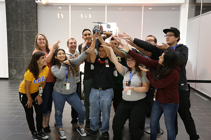 The Gold Team poses for a group photo in front of the Mars Curiosity rover model at JPL