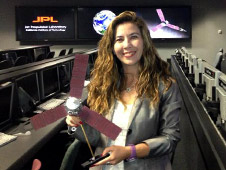Michela Munoz Fernandez in JPL mission control with a model of the Juno spacecraft