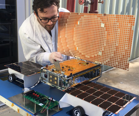 JPL engineer Joel Steinkraus works with one of the MarCO CubeSats during an outdoor test of its solar arrays.