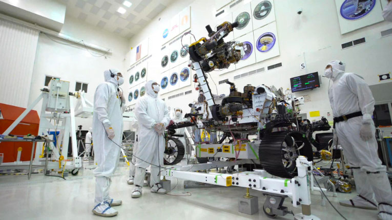 Engineers in clean suits working on the rover