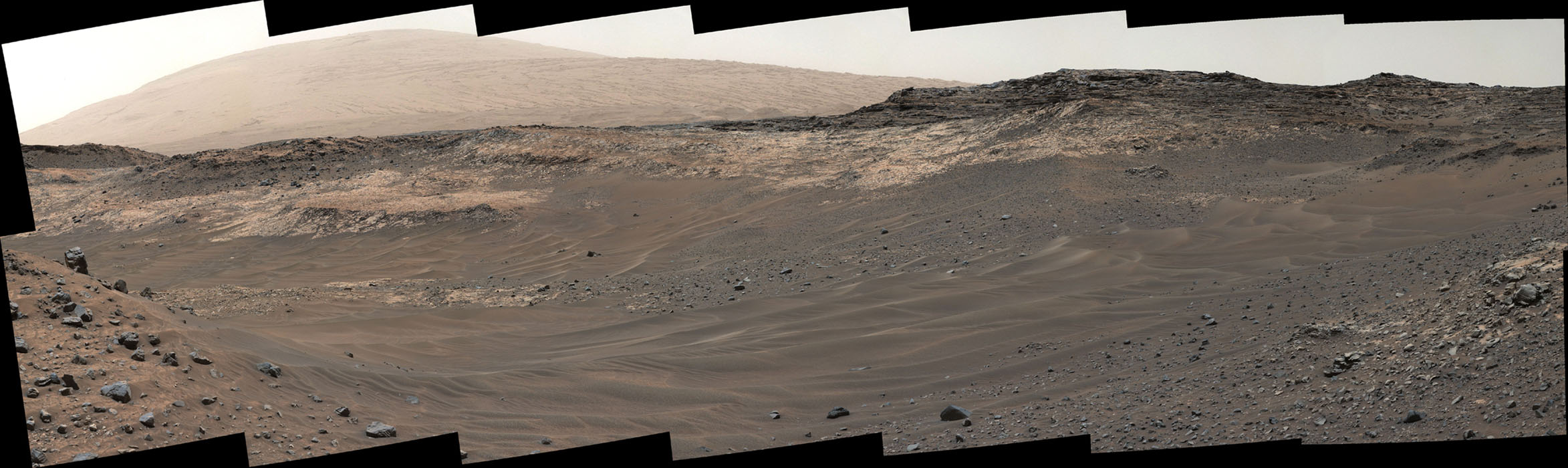 This view southeastward from Curiosity's Mast Camera (Mastcam) shows terrain judged difficult for traversing between the rover and an outcrop in the middle distance where a pale rock unit meets a darker rock unit above it.