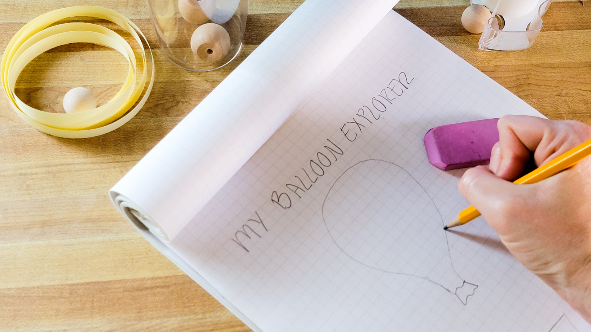 A person sketches a balloon on graph paper.
