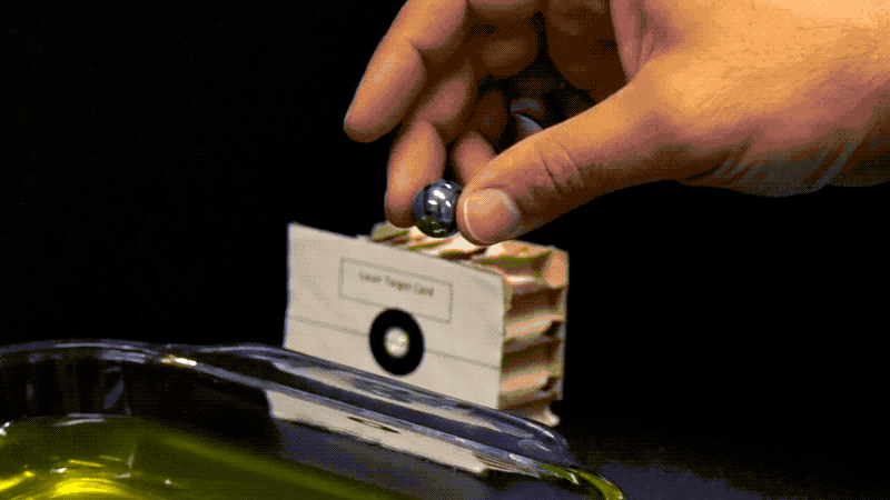 Animated image showing a marble dropping on top of another marble set in gelatin