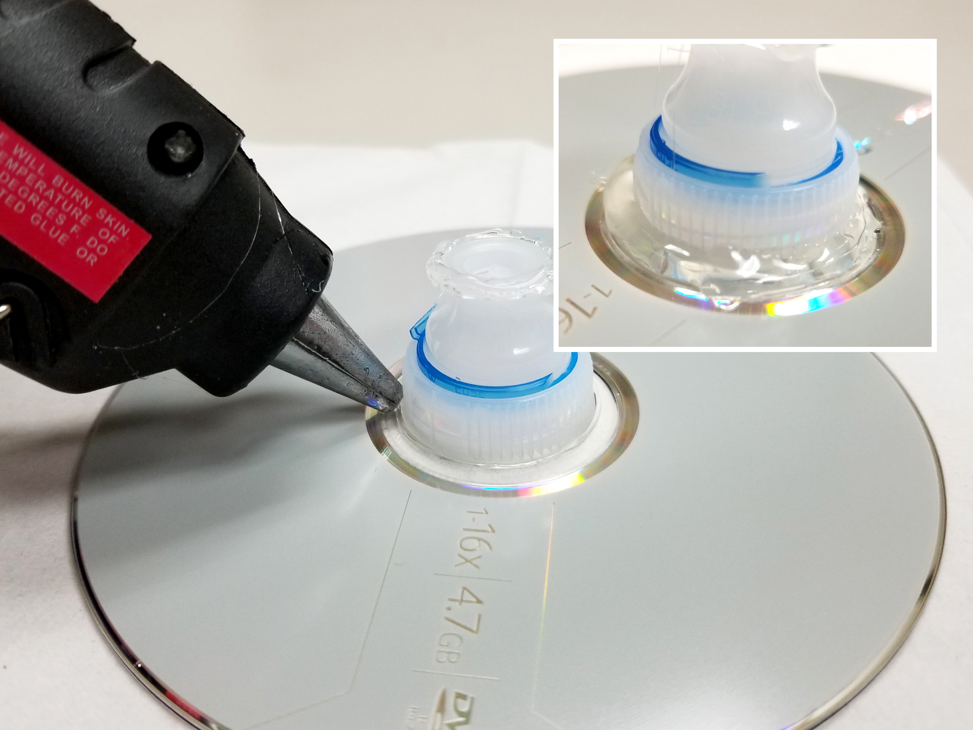 Adding more glue where water bottle top meets CD