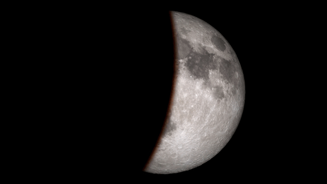 A dark shadown covers half of the Moon making it look as if a bite has been taken out of it.