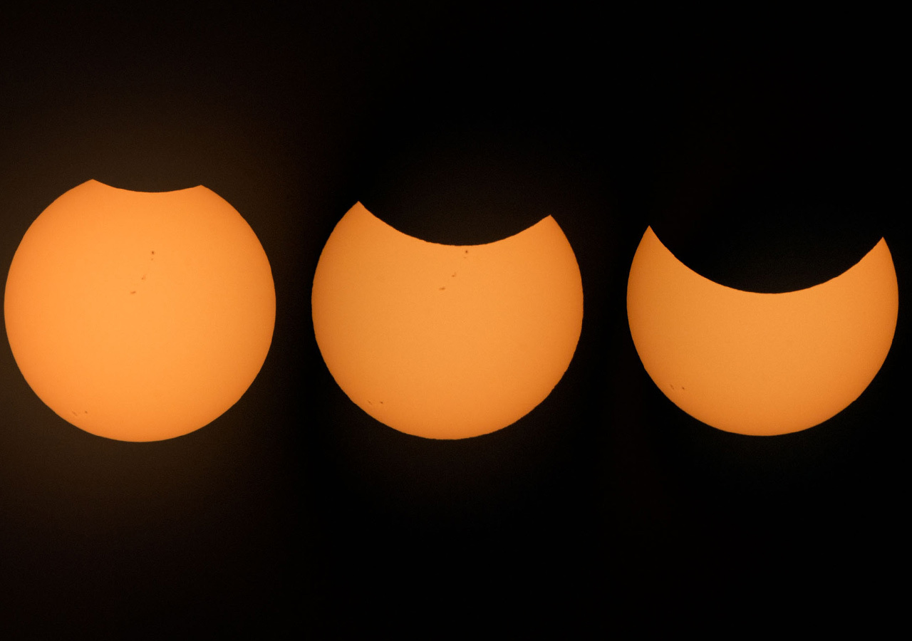 A series of three images show the Sun being progressively more eclipsed by the Moon from left to right.