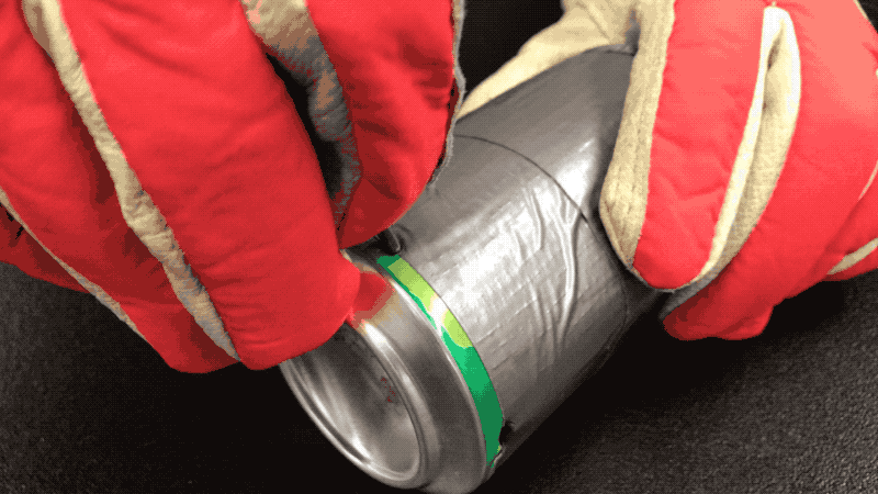 A nail is inserted into one of the holes in the can and pulled down toward the can to make an angled hole.
