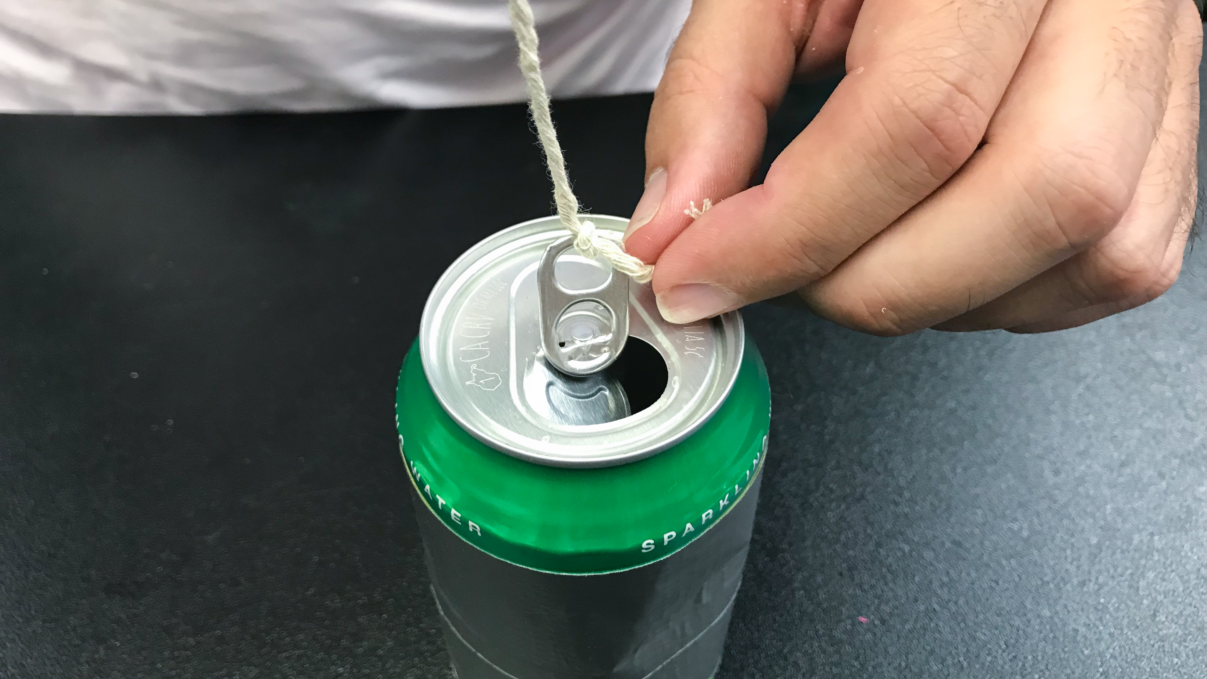 A string is tied to the pop tab of the can.