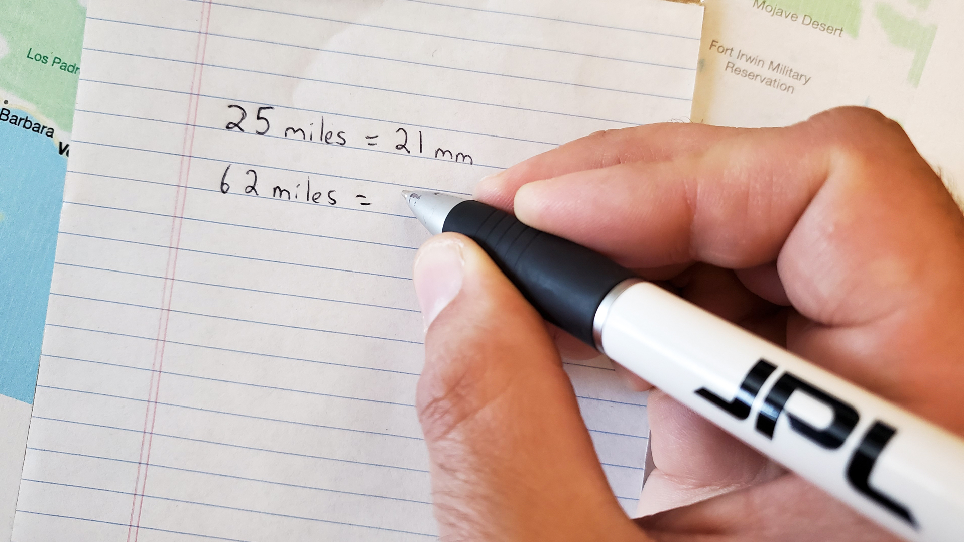 A person writes out their calculation on a piece of paper