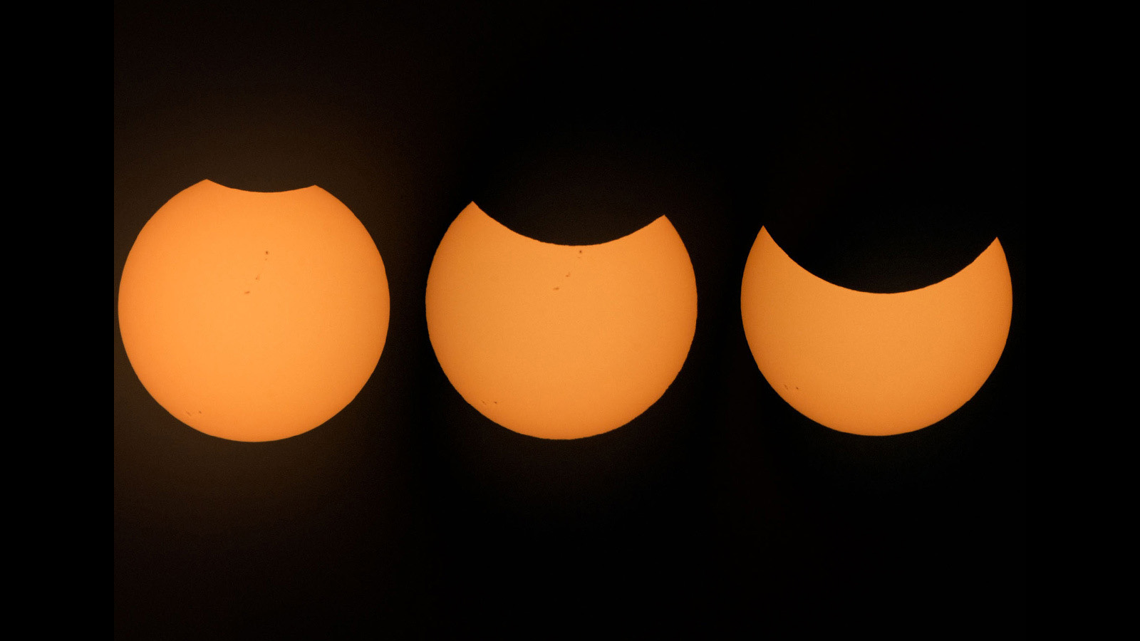 The Sun appears to have a small bite taken out of the top of its yellow-orange disk. The bite grows in size in this sequence of three images.