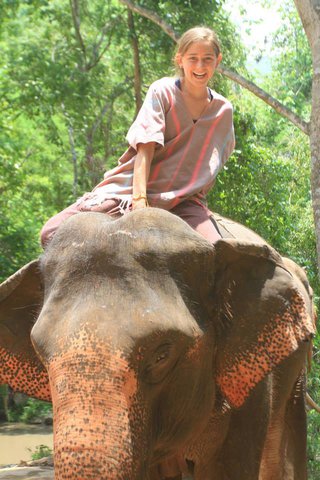 Rebecca Gustine smiles for a photo atop an elephant.