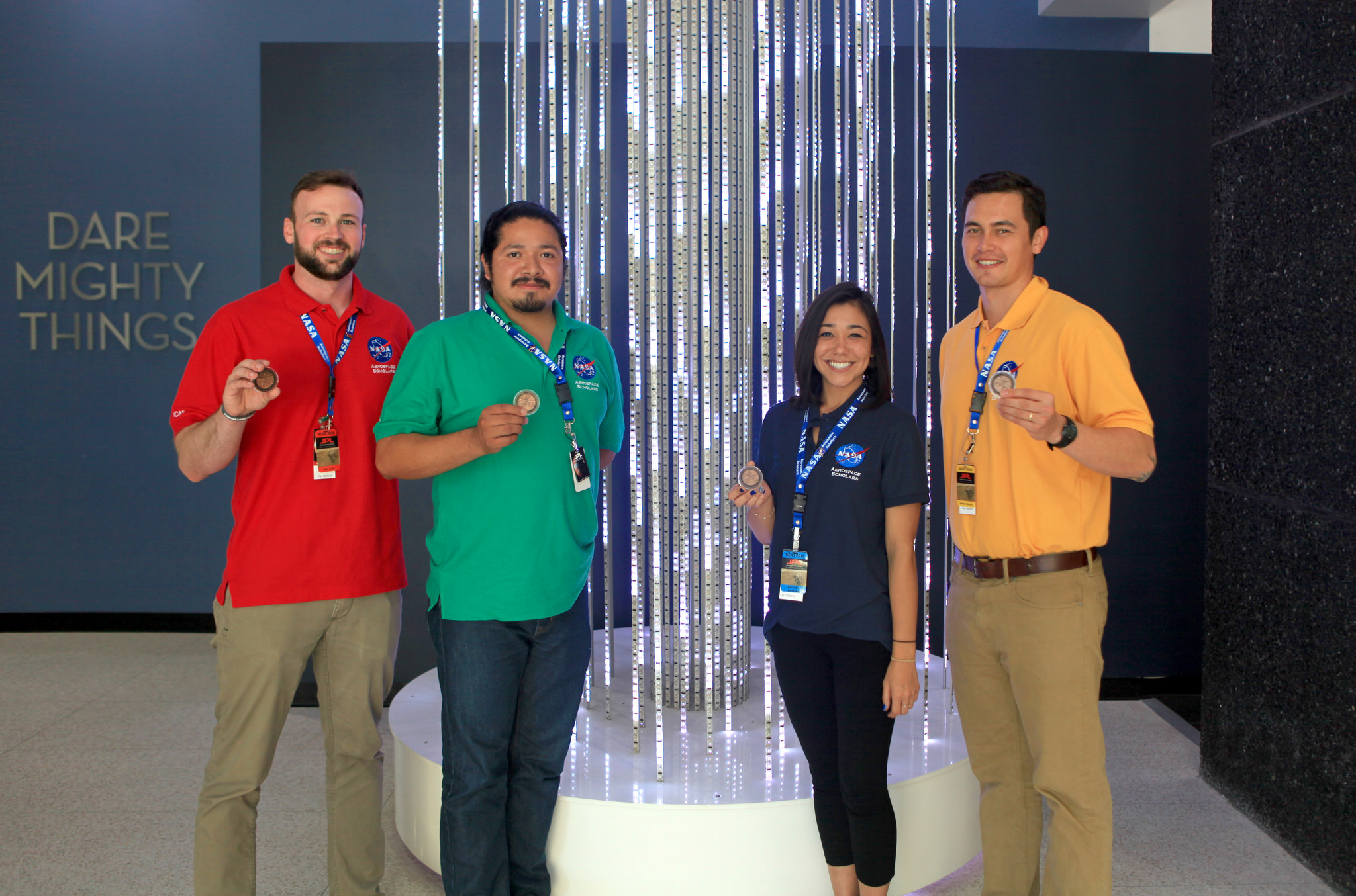 Ryan Loper poses in front of a light sculpture at JPL with other NCAS participants