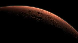 Artist's concept of sunrise over Mars from orbit.