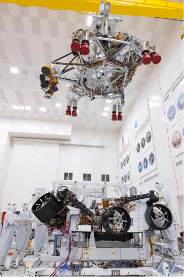 Engineers in clean suits working on the rover