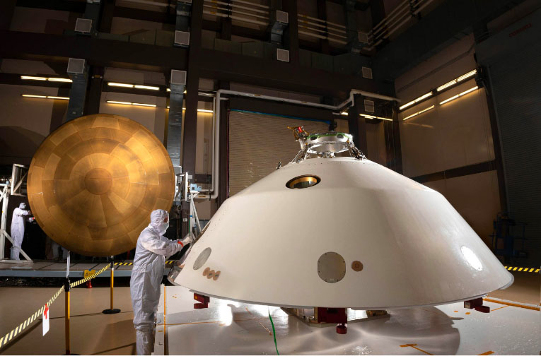 Engineers in clean suits working on the rover