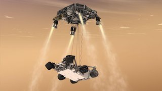 This artist's concept shows the sky crane maneuver during the descent of NASA's Curiosity rover to the Martian surface. The sheer size of the rover (over one ton, or 900 kilograms) would preclude it from taking advantage of an airbag-assisted landing.