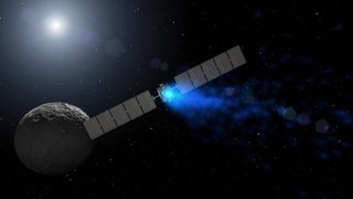This artist's rendering shows NASA's Dawn spacecraft maneuvering above Ceres with its ion propulsion system. Dawn arrived into orbit at Ceres on March 6, 2015, and continues to collect data about the mysterious and fascinating world.